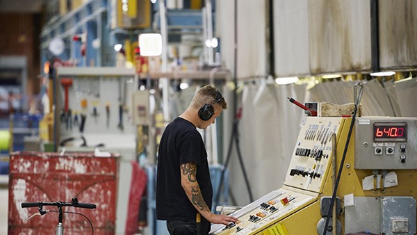 En man med hörselkåpor i arbete vid en kontrollpanel