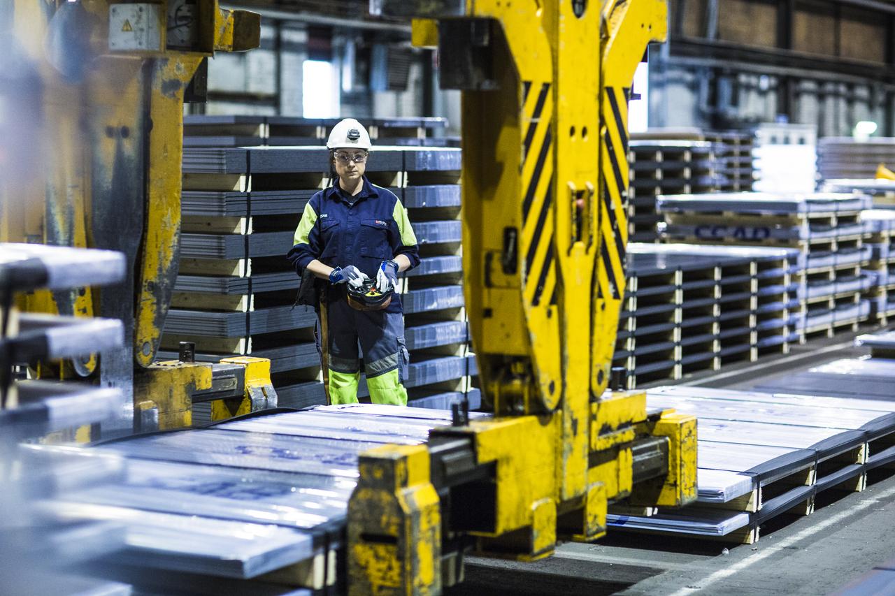 Person standing on the floor, operating a crane. 